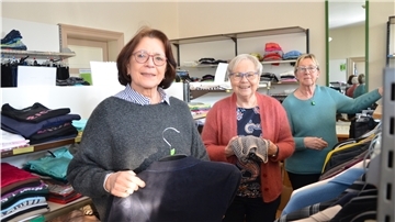 Monika Paulsen, Anke Schnaars und Marita Schilling (von links) hängen die neue Kleidung auf.