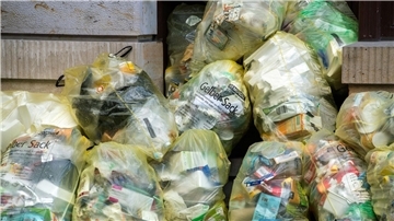 Müllbeutel „Gelber Sack“ liegen in der Altstadt auf einem Fußweg vor einem Haus. Die EU einigt sich auf eine Reform für weniger Verpackungsmüll bis 2030.