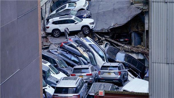 Einsturz eines Parkhauses in New York - Mindestens ein Toter Nach dem Einsturz eines Parkhauses in New York: Autos stapeln sich übereinander, zahlreiche Fahrzeuge wurden zusammengedrückt.