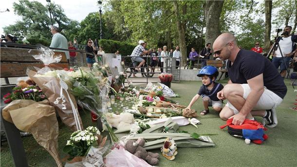 Nach dem Messerangriff in Annecy haben Menschen in der Nähe des Tatorts Blumen und Kuscheltiere abgelegt und gedenken der Opfer.