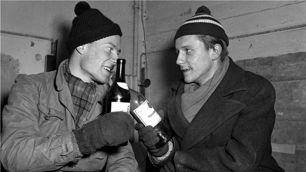 René Leudesdorff (l) und Georg von Hatzfeld stoßen im Flakbunker auf der Insel Helgoland mit jeweils einer Flasche Wein an.
