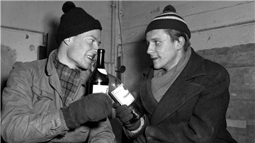 René Leudesdorff (l) und Georg von Hatzfeld stoßen im Flakbunker auf der Insel Helgoland mit jeweils einer Flasche Wein an.