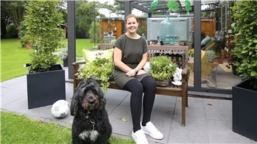 Kim Terhaag sitzt auf einer Bank im Garten.