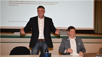 Nach der Wahl zum Ratsvorsitzenden: Ralf Töllner (stehend) freut sich. Auch Bürgermeister Axel Linneweber ist gut gelaunt.