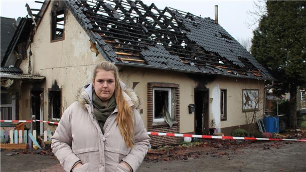 Nachbarin Lena Schmidt vor der Brandruine in Lunestedt. Die 26-Jährige hat eine Spendenaktion für die Opfer der Brandkatastrophe ins Leben gerufen.