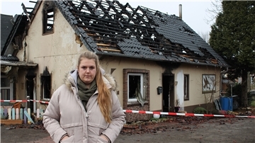 Nachbarin Lena Schmidt vor der Brandruine in Lunestedt. Die 26-Jährige hat eine Spendenaktion für die Opfer der Brandkatastrophe ins Leben gerufen.