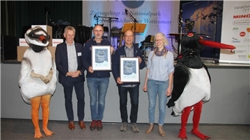 Nationalpark-Leiter Peter Südbeck (Zweiter von links) und Aviathlon-Koordinatorin Nadine Knipping überreichten zusammen mit „Sandi“ und „Austi“ die Urkunden an Mathias Heckroth (für das Team Insel Wangerooge) und Jan Richert (Team Cuxhaven).