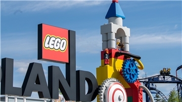 Neben dem Logo am Eingang zum Legoland ist die Achterbahn (r) des Freizeitparks zu sehen (Archivbild).