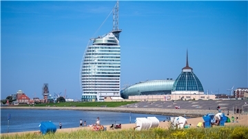 Strandkörbe stehen am Weserufer vor dem Klimahaus und dem Atlantic Hotel in Bremerhaven.