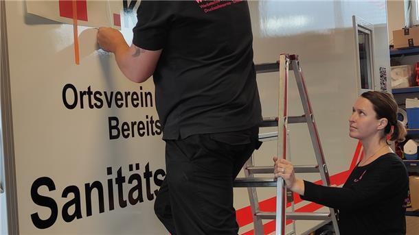 Nina und Bastian Pommert von der Firma 4-Elements bekleben die neue Sanitätswachstation im DRK-Bereitschaftsgebäude in Tarmstedt.