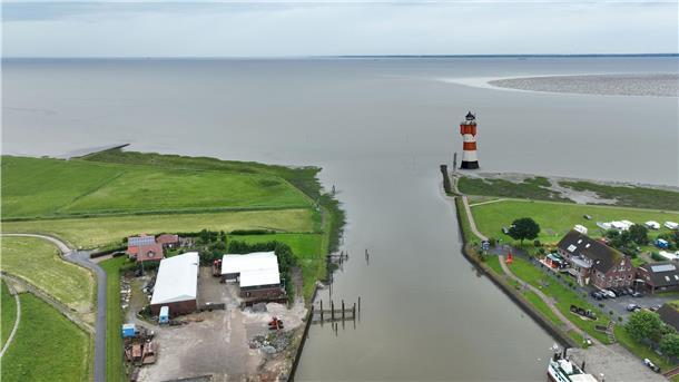 Luftbild eines Hafens an der Nordsee mit einem Leuchtturm an der Hafenausfahrt