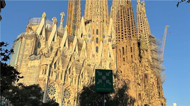 Kreuz aus Deutschland auf der Sagrada Familia vor Vollendung Noch verdecken ein Baugerüst und ein großer gelber Kran die Spitze des Hauptturms der Sagrada Familia.