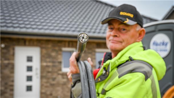 Nun macht die Firma Wähler die Anschlüsse für Strom, Wasser und Telekomminukation des Traumhauses. Hier zeigt Siegfried Pötter das Stromkabel.