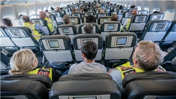 Sitzreihen mit Passagieren in einem Flugzeug