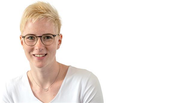 Haben Sie heute schon an die Sonne gedacht? Eine Frau mit kurzen Haaren und Brille lächelt in die Kamera.