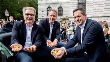Oberbürgermeister Jürgen Krogmann (SPD) sowie die Ministerpräsidenten Daniel Günther (CDU) und Olaf Lies (SPD) sitzen in der Kutsche des Festumzugs zum diesjährigen Kramermarkt in Oldenburg.