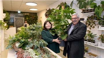 Oberbürgermeister Melf Grantz beglückwünscht Inhaberin Boram Lee und kauft eine Monstera.