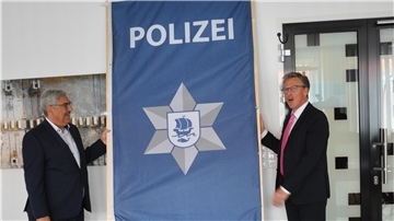 Oberbürgermeister Melf Grantz (links) und Harry Götze, der Direktor der Ortspolizeibehörde, bei der Enthüllung des neuen Logos. Der Polizei-Stern wirkt nun moderner.