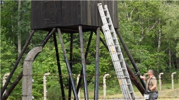 Obergefreiter d .R. Tobias Reschke von der Zevener Reservistenkameradschaft bei den Malerarbeiten am Wachturm in Polen.