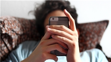 Ein Jugendlicher am Smartphone.