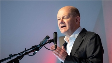 Bundeskanzler Olaf Scholz redet in ein Mikorofon
