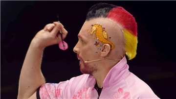 Oliver Pocher tritt mit neuer Frisur und einem Seepferdchen-Sticker an. Dann wirft er bei der  Promi-Darts-WM 2023 einen Pfeil.