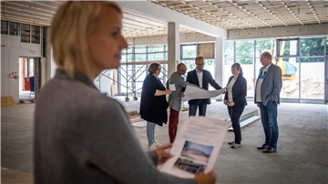 Ortsbesichtigung im Mensa-Neubau der Karl-Marx-Schule Bremerhaven-Leherheide mit  Architektin Nina Goldschrafe (vorn) mit Martina Kirschstein-Klingner (SPD), Baustadtrat Bernd Schomaker (FDP), Betriebsleiter Holger Schneeberg, seiner Stellvertreterin Isabelle Bornemann und Thorsten Raschen (CDU). 