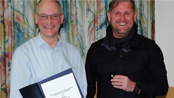 Ortsbürgermeister Detlef Kück erhält von Gnarrenburgs Gemeindebürgermeister Marc Breitenfeld eine Urkunde.