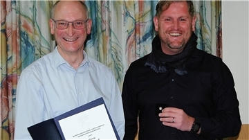 Ortsbürgermeister Detlef Kück erhält von Gnarrenburgs Gemeindebürgermeister Marc Breitenfeld eine Urkunde.