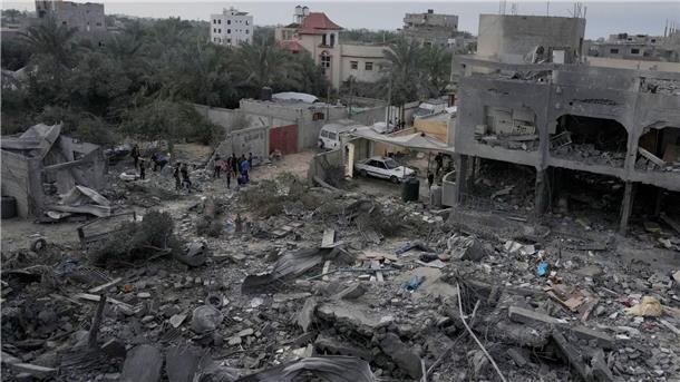 Palästinenser betrachten die Trümmer eines Gebäudes im Zenrum des Gazastreifens, das bei einer israelischen Bombardierung zerstört wurde.