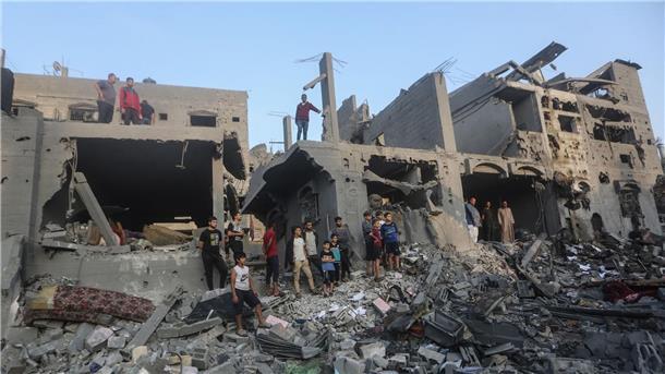 UN beklagen Tausende getötete Kinder im Gazastreifen Palästinenser durchsuchen Gebäude, die bei israelischen Luftangriffen zerstört wurden.