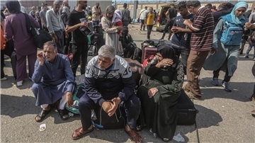 Palästinenser, einige mit ausländischen Pässen, warten am Grenzübergang Rafah auf Hilfe und eine mögliche Einreise nach Ägypten.