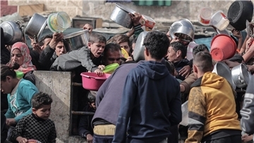 Palästinenser warten an einer Spendenstelle in einem Flüchtlingslager im südlichen Gazastreifen auf Lebensmittel.