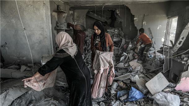 Palästinenserinnen suchen in einem zerstörten Haus in Rafah nach Habseligkeiten.