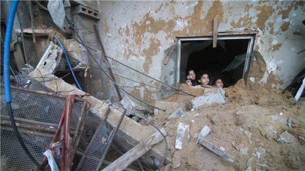 Bodenoffensive in Gaza erwartet - Nahost-Flächenbrand droht Palästinensische Kinder schauen in Rafah im Süden des Gazastreifens aus einem Fenster, das bei israelischen Luftangriffen zerstört wurde.