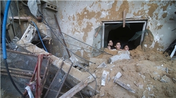 Palästinensische Kinder schauen in Rafah im Süden des Gazastreifens aus einem Fenster, das bei israelischen Luftangriffen zerstört wurde.