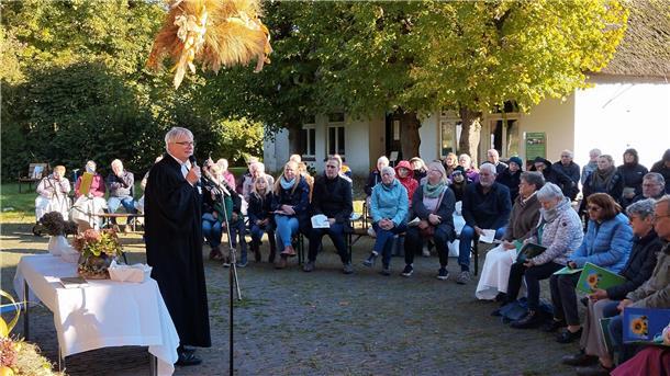 Ein Pastor steht am Mikrofon und hält eine Rede. 
