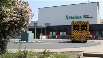 Ein Rettungswagen fährt vor einem Krankenhaus vor. 