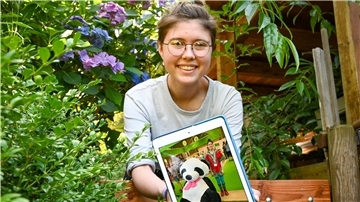 Eine Frau präsentiert ein Bild von sich.