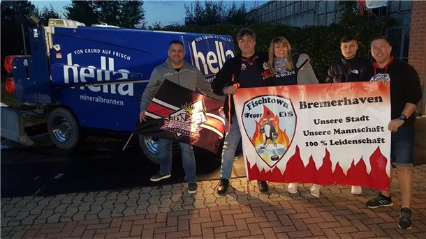 Liveticker: Die Fischtown Pinguins und ihr Abenteuer in Prag Menschen mit Banner vor Eismaschine.