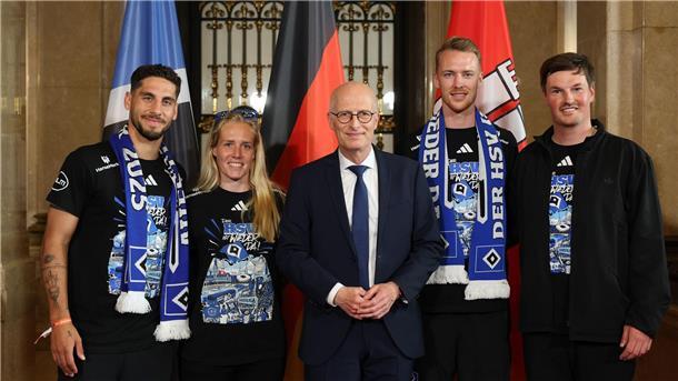 Aufstiegsparty: HSV verwandelt Innenstadt in Partymeile Peter Tschentscher (M, SPD), Erster Bürgermeister und Präsident des Senats der Freien und Hansestadt Hamburg, steht mit Hamburgs Ludovit Reis (l-r), Sarah Stöckmann, Sebastian Schonlau und Trainer Merlin Polzin auf dem Spiegel im Rathaus.
