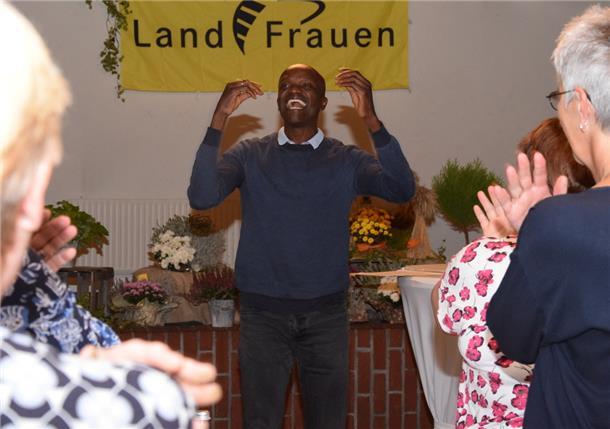 Dieser Mann stieg vom Straßenkind zum Lehrer auf Philip Oprong Spenner aus Kenia, heute Lehrer in Hamburg, bringt die Landfrauen mit kleinen Übungen in Schwung, bevor er über sein von krassen Kontrasten geprägtes Leben erzählt.