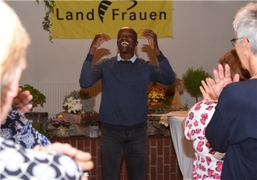 Philip Oprong Spenner aus Kenia, heute Lehrer in Hamburg, bringt die Landfrauen mit kleinen Übungen in Schwung, bevor er über sein von krassen Kontrasten geprägtes Leben erzählt.
