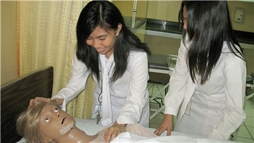 Philippinische Krankenschwesternschülerinnen lernen an einer Puppe mit europäischen Ausmaßen und Gesichtszügen. Die Philippinen bilden Pflegepersonal für die ganze Welt aus.