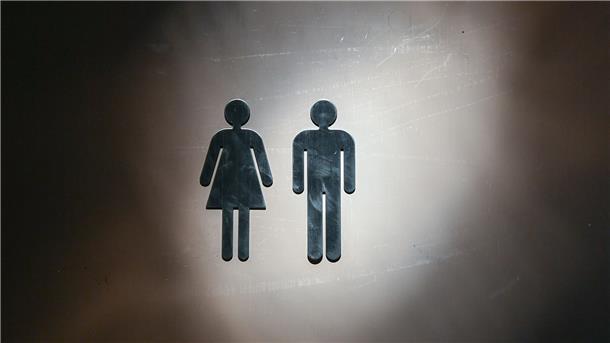 Immer mehr Unisex-Toiletten an Schulen in Niedersachsen Piktogramme für eine Frau und ein Mann sind an einer Tür angebracht.