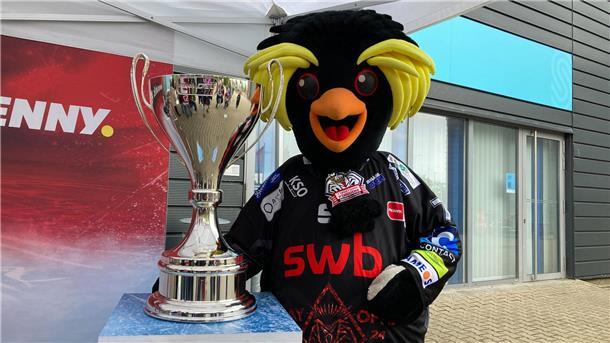 DEL-Trophäe zu Gast in Bremerhaven: Was die Fans an dem Pokal fasziniert Pinguins-Maskottchen Kralli präsentiert die DEL-Trophäe vor der Eishalle. Die Fans würden dem Pokal am liebsten in Bremerhaven behalten.