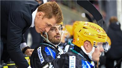 Ein Eishockey-Trainer beugt sich runter zu seinem Spieler und bespricht Details. Pinguins-Coach Alexander Sulzer zieht eine positive Saison-Bilanz.