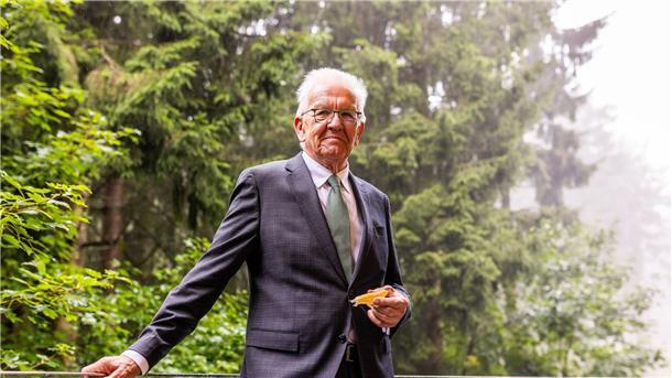 Politiker Winfried Kretschmann zeigt ein vergrößertes Modell des Bärtierchens, das nach ihm benannt ist.