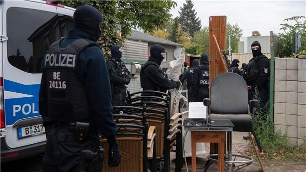 Polizeibeamte stehen am Gelände der Rockergruppe „Hells Angels MC Berlin Central“ in Berlin zwischen sichergestellten Gegenständen.