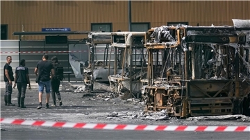 Polizeiermittler vor ausgebrannten Bussen in Aubervilliers.